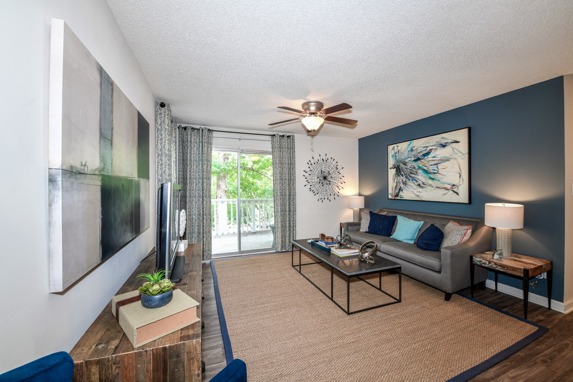 an open living room with a couch and a ceiling fan